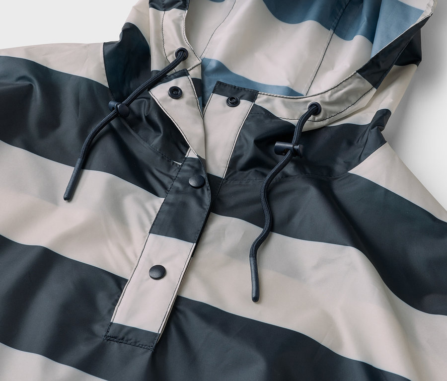 Nahaufnahme einer gestreiften Regenjacke in Grau und Weiß mit Kapuze und Kordelzug.