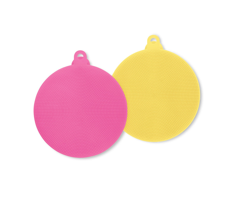 Ein pinker und ein gelber runder Silikon-Gesichtspeeling-Pad liegen übereinander.