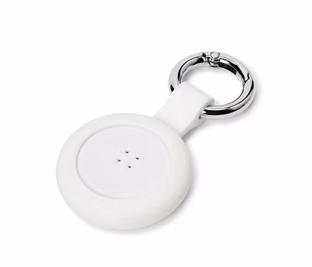 Nahaufnahme eines weißen, runden Ortungsgeräts mit vier Löchern und einem silbernen Karabiner.