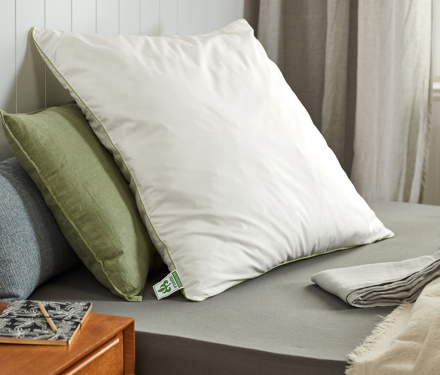 Mehrere irisette® greenline Kopfkissen in verschiedenen Größen liegen auf einem Bett.