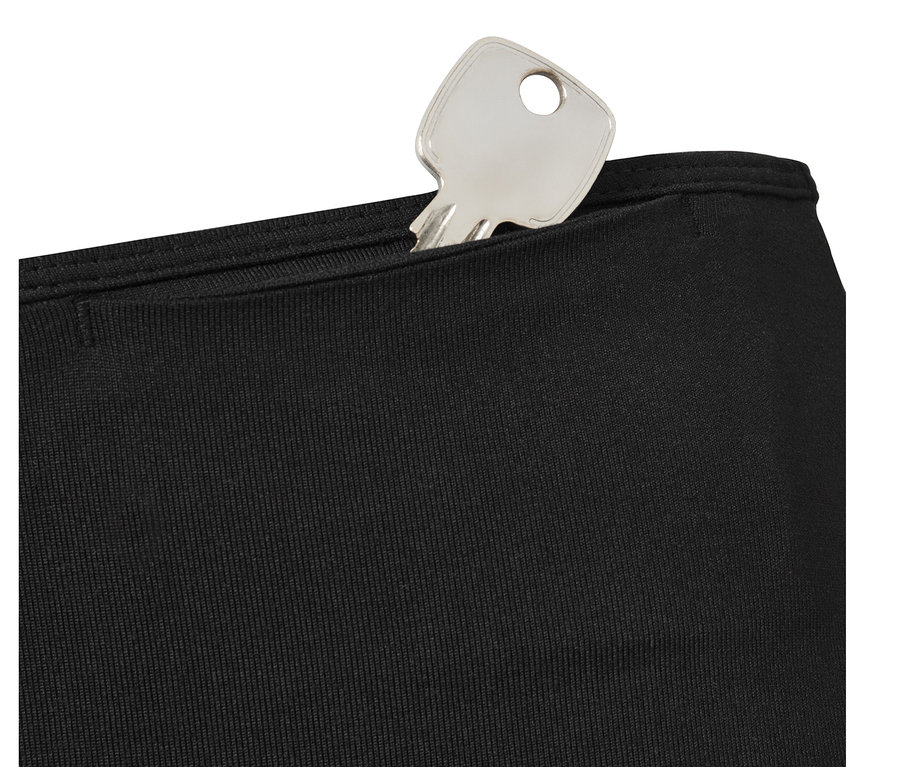 Ein silberner Schlüssel in der Tasche einer schwarzen Sporttight.