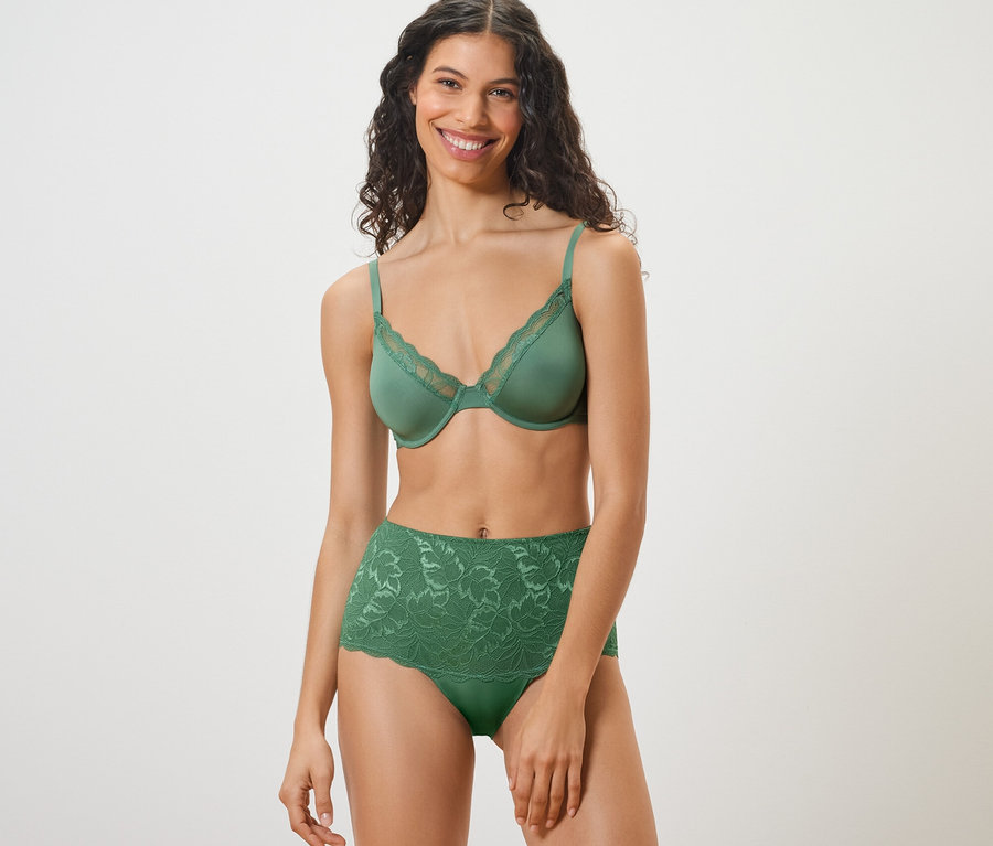 Lächelnde Frau trägt einen grünen BH und eine grüne Highwaist-Panty »light-shaping«.