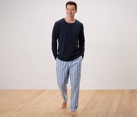 Mann geht, trägt einen Pyjama mit gewebter Hose.