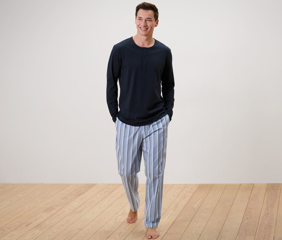 Mann geht, trägt einen Pyjama mit gewebter Hose.