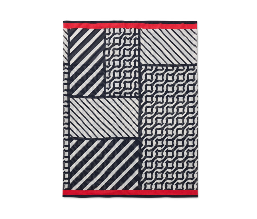 Ein bedruckter Loop-Schal mit geometrischen Mustern und rotem Saum.