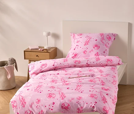 Rosa Bettwäsche mit Ballerina-Motiven auf einem Bett.