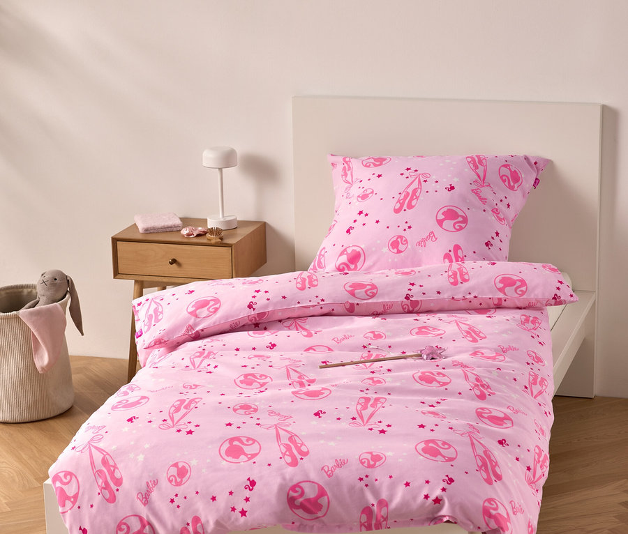 Rosa Bettwäsche mit Ballerina-Motiven auf einem Bett.