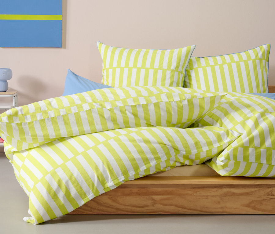Limefarbene Renforcé-Bettwäsche in Normalgröße auf einem Bett.