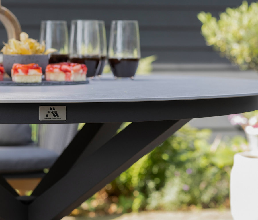 Auf einem deVries Tisch mit ca. 120 cm Durchmesser stehen Süßspeisen und Getränke.