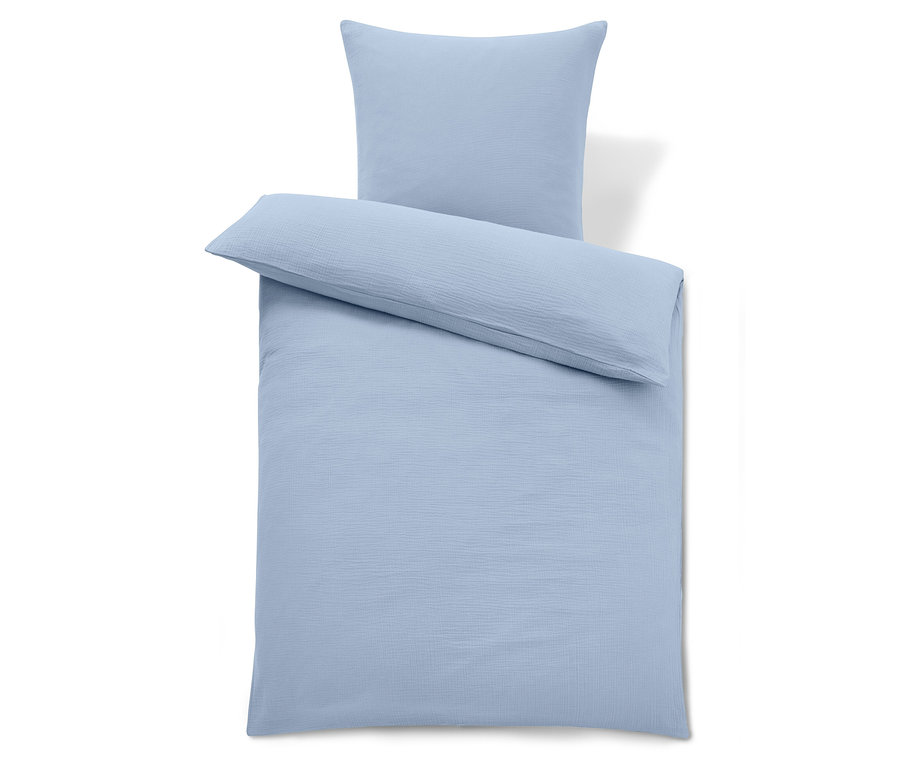 Hellblaue Bettwäsche mit Kissen oben.