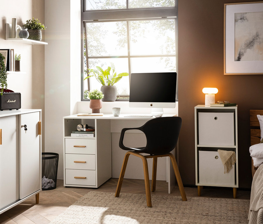 Ein Zimmer mit einem Schreibtisch, einem Computer und dem Regal »Torge« mit 2 Faltboxen, matt weiß.