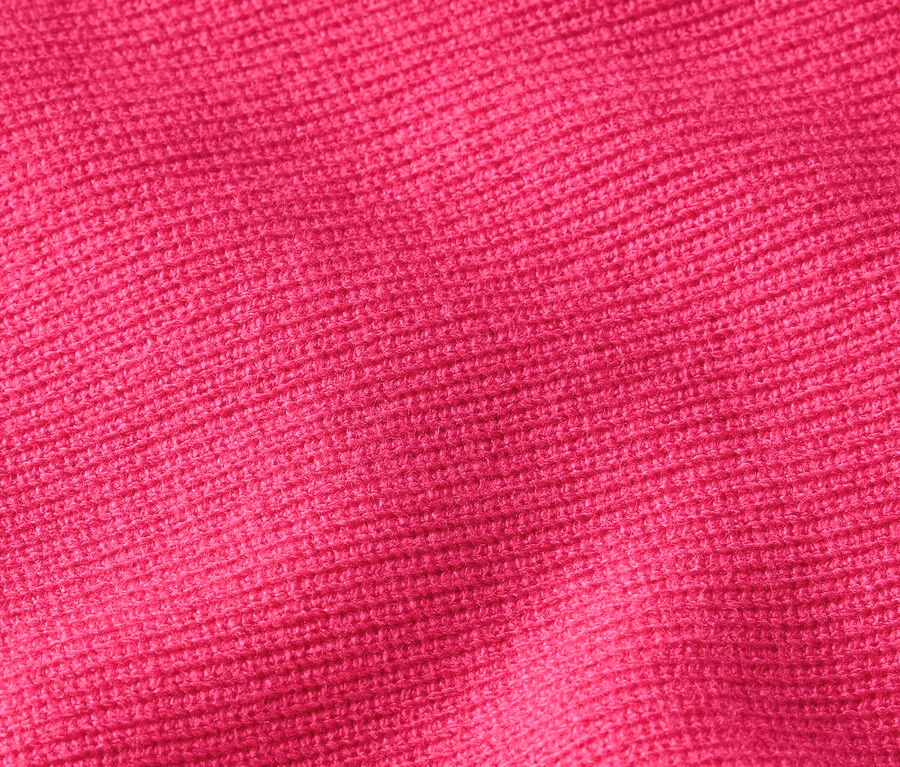 Nahaufnahme der Textur eines Strickstoffs in leuchtendem Pink.