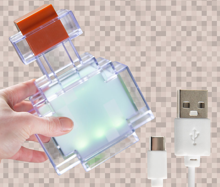 Eine Hand hält eine MINECRAFT LED Dekoleuchte in Form eines Tranks, daneben liegen zwei USB-Kabel.