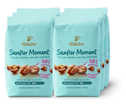 Mehrere Packungen Tchibo Sanfter Moment Kaffee mit 50% Koffein. Die Packungen sind hellblau und zeigen Kaffeebohnen.