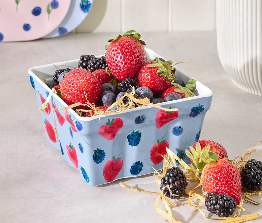 Eine Erdbeerschale gefüllt mit Erdbeeren, Blaubeeren und Brombeeren.