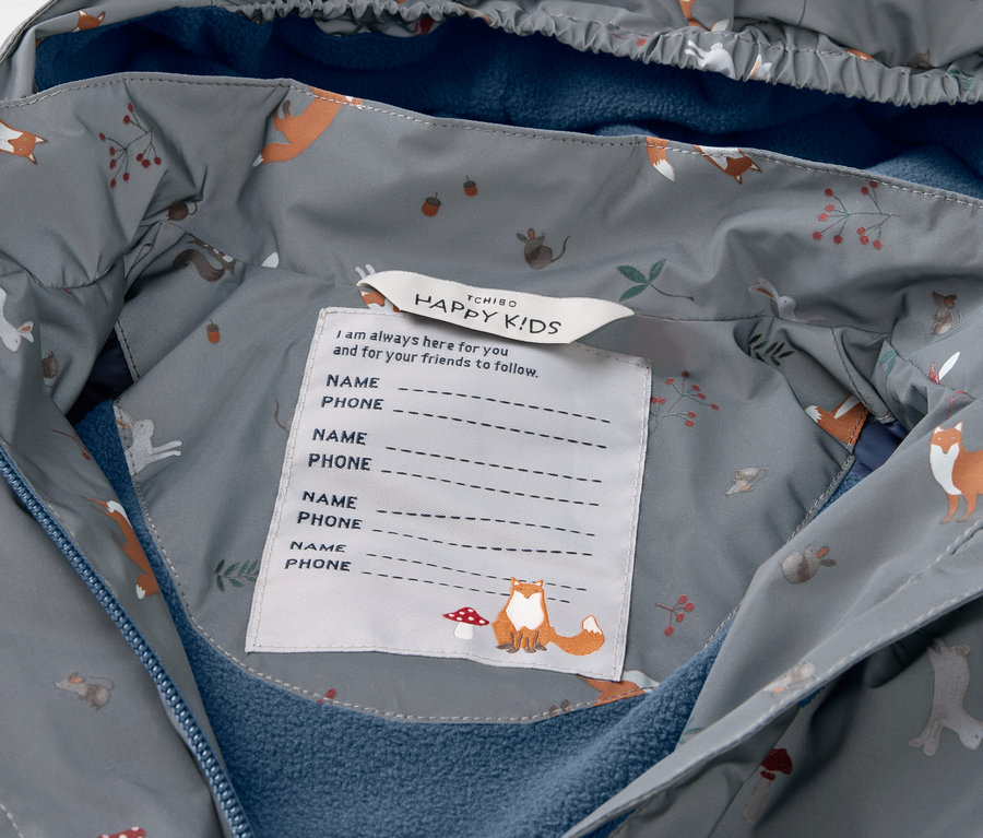 Detail einer Kinder-Thermo-Regenjacke mit reflektierenden Elementen.