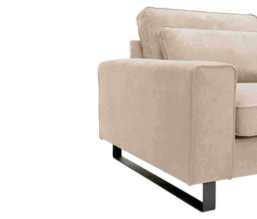 Nahaufnahme eines beigen Sofas mit schwarzen Metallfüßen.