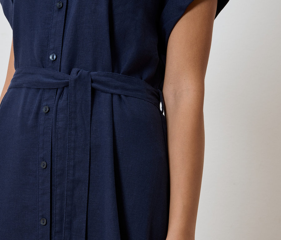 Nahaufnahme eines marineblauen Hemdkleid mit Knopfleiste und Stoffgürtel.