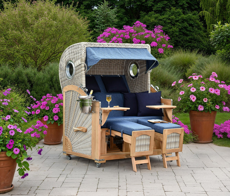 Ein geflochtener Strandkorb mit blauem Bezug steht auf einer Terrasse, umgeben von Blumen.