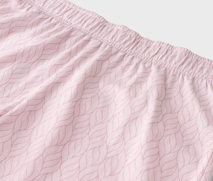 Nahaufnahme der Taille einer hellrosa Hose mit elastischem Bund und Blattmuster.