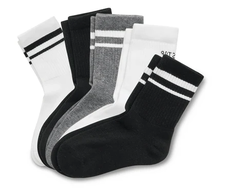 Mehrere Socken in Weiß, Grau und Schwarz sind gestapelt.