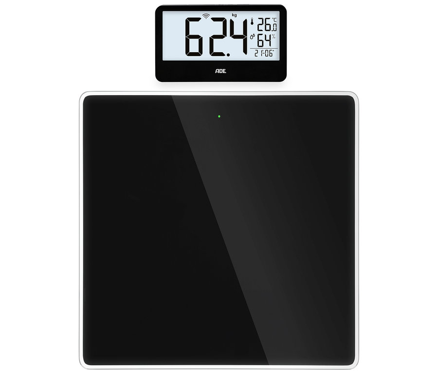 Schwarze digitale Personenwaage mit separatem Display, das 62,4 kg, 26,0 °C, 64 % Luftfeuchtigkeit und 21:06 Uhr anzeigt.
