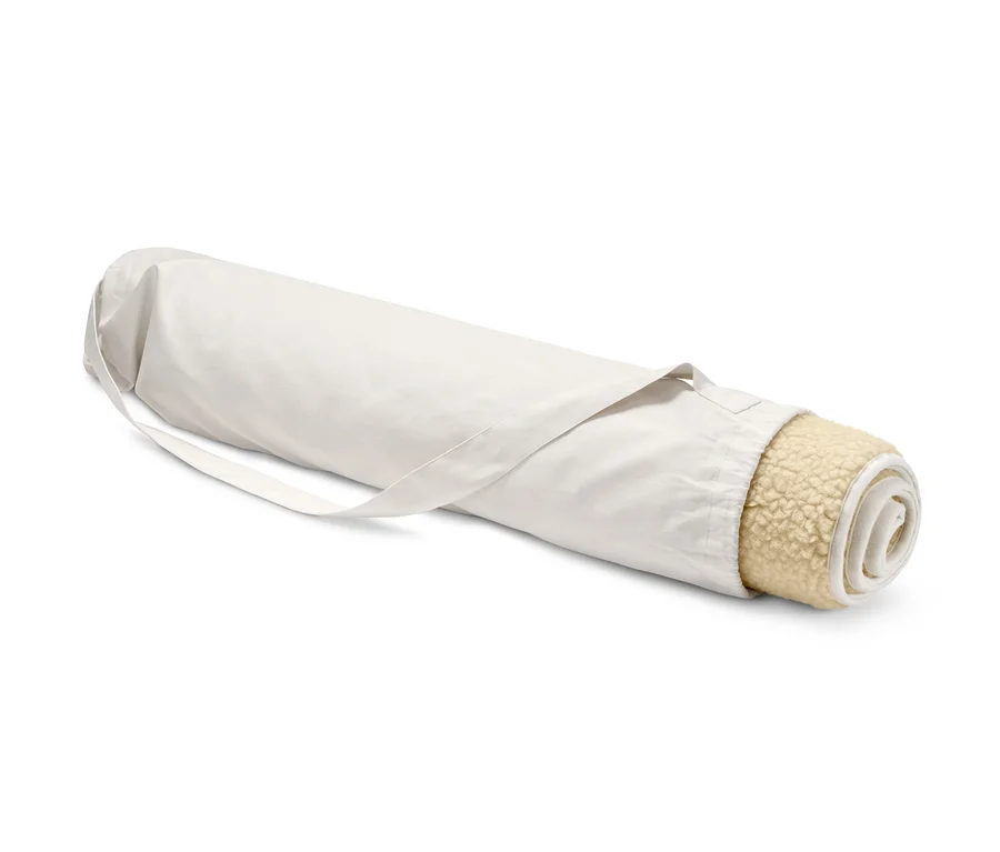 Eine zusammengerollte Schurwoll-Yogamatte in einer Tasche.