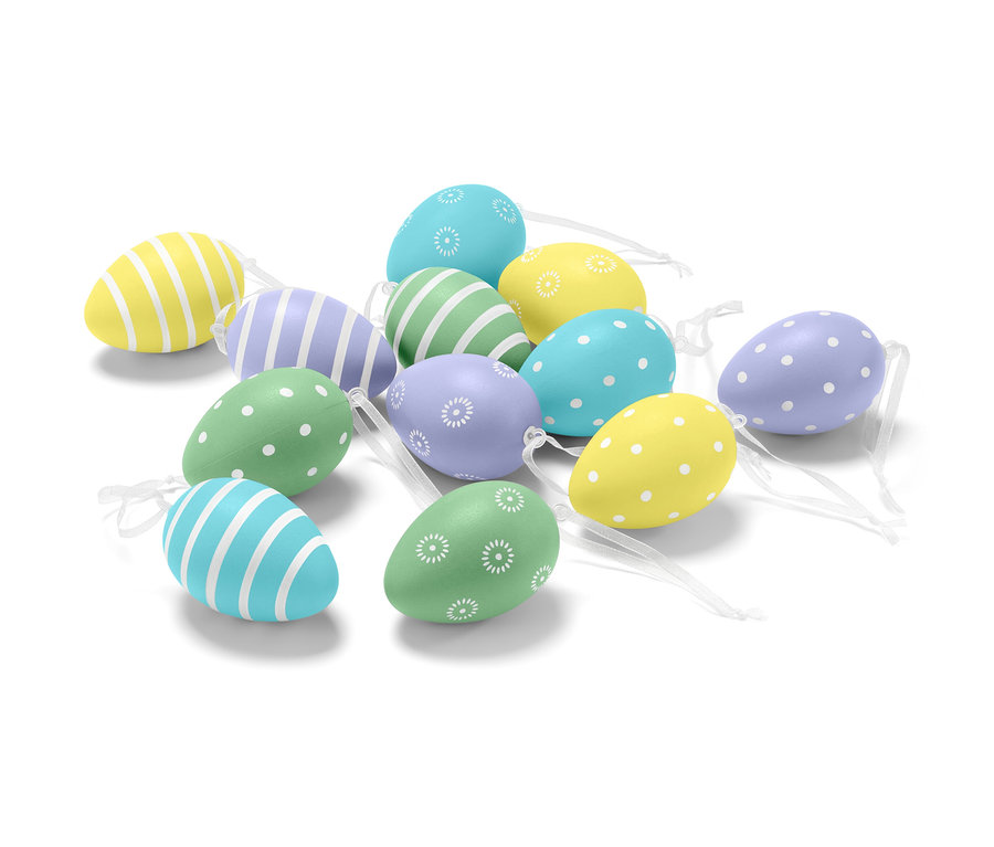 Zwölf Ostereier in verschiedenen Farben und Mustern liegen auf weißem Grund.