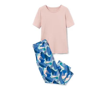 Ein rosa Pyjamaoberteil und eine blau gemusterte Pyjamahose liegen auf einem weißen Hintergrund.