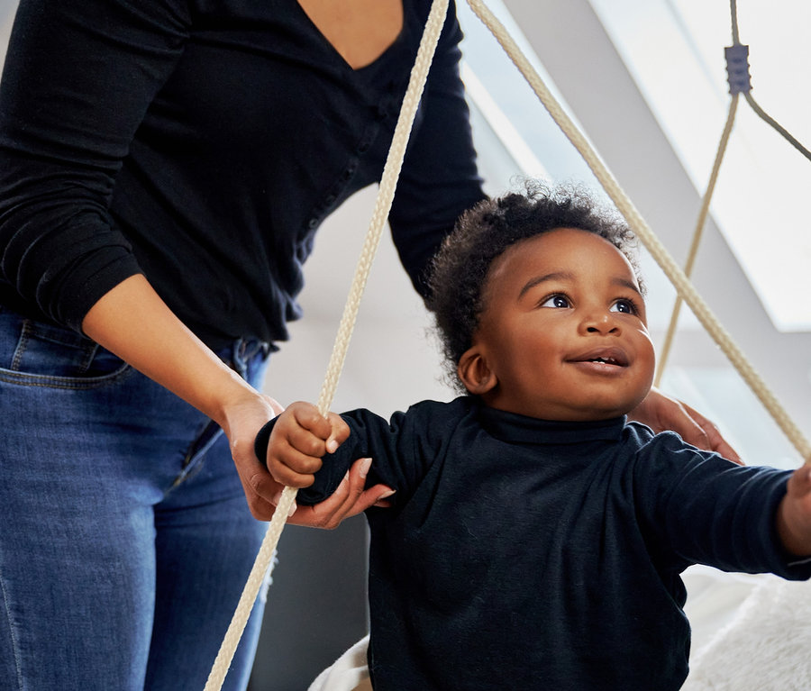 Eine Mutter schaukelt ein kleines Kind in einer schwarzen HUDORA Nestschaukel »Lounge«.