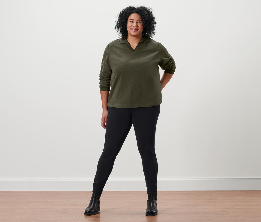 Frau posiert in Sweatshirt mit Polokragen, Jeggings und Lederboots.