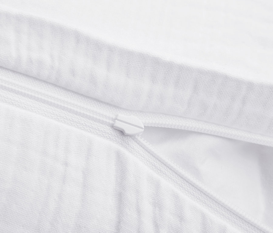 Detailaufnahme eines weißen Bettbezugs mit Reißverschluss.