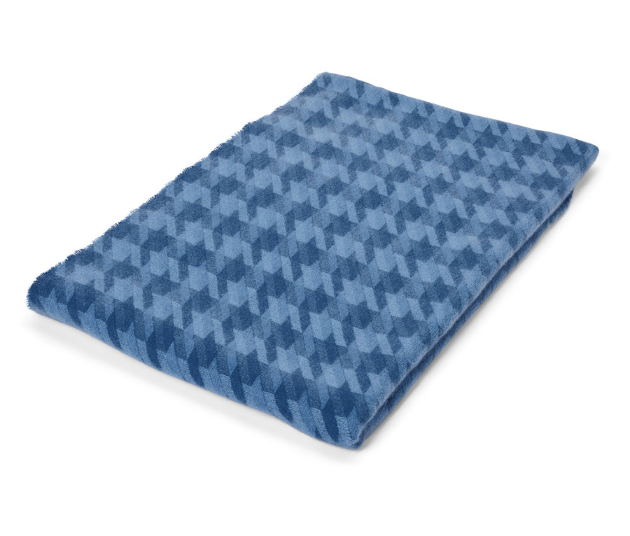 Zusammengelegte blaue Decke mit geometrischem Muster.