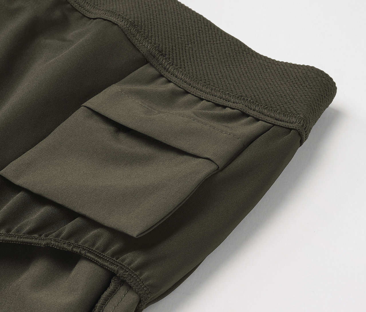 Detail einer olivgrünen Cargohose mit Tasche.