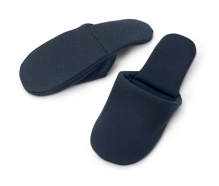 Zwei Paar marineblaue Reise-Hausschuhe liegen auf einem weißen Hintergrund.