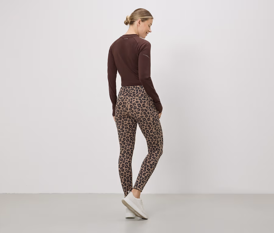 Eine Frau von hinten, mit braunem Oberteil, Leggings mit Leopardenmuster und weißen Turnschuhen.