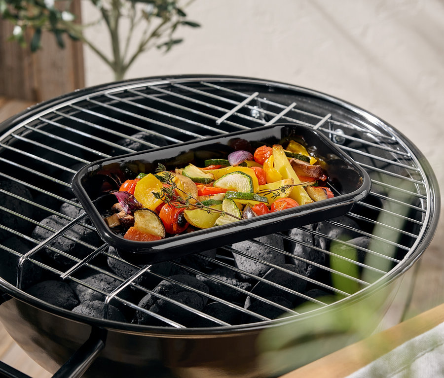 Gemüse in einer schwarzen Auflaufform auf einem Grill.