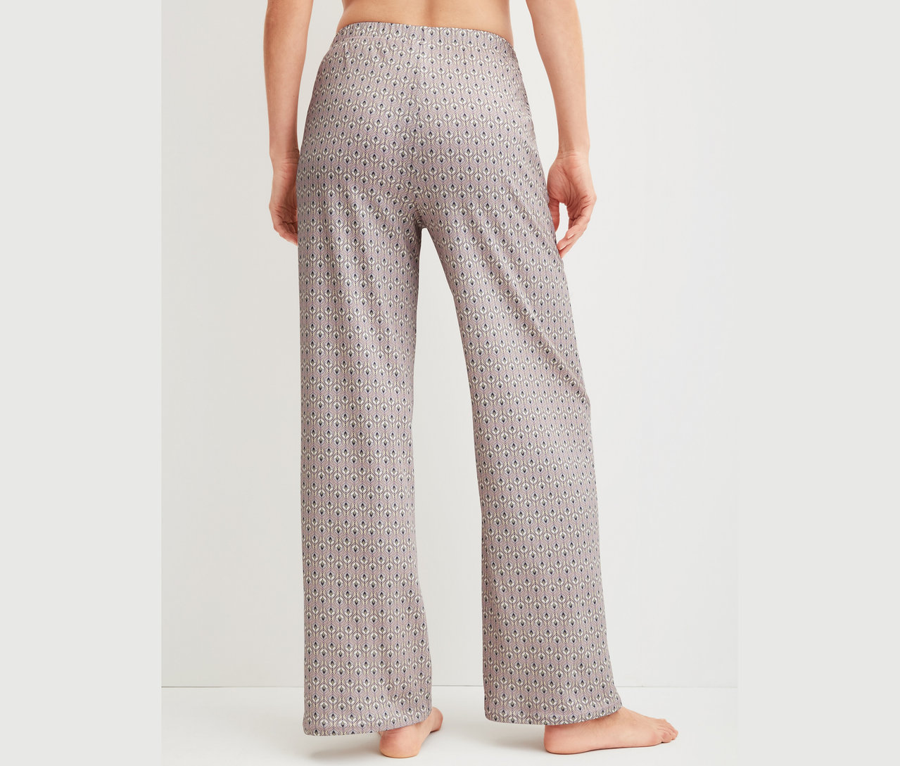 Nahaufnahme der Rückansicht einer Frau, die gemusterte Pyjamahose trägt.