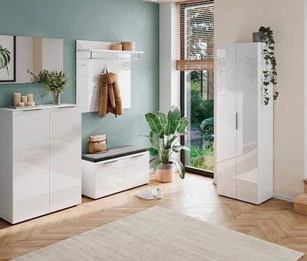 Eingangsbereich mit weißen Möbeln, darunter Schuhschrank, Garderobe und Bank, sowie Pflanzen und Deko.
