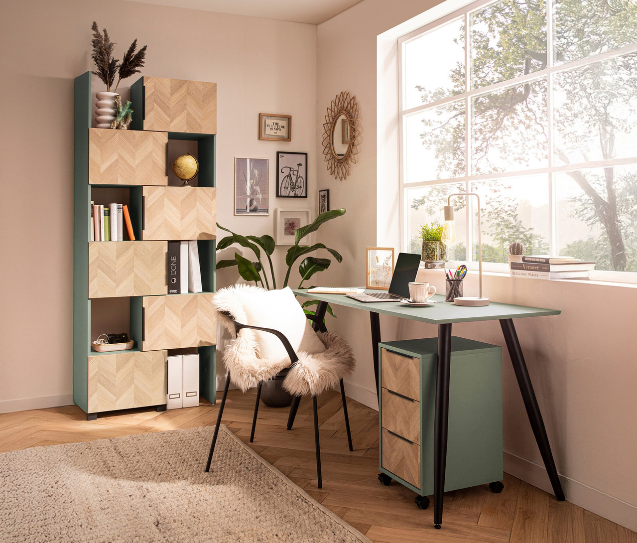 Ein Arbeitszimmer mit einem mintgrünen Schreibtisch, einem Bücherregal und einem Stuhl mit Fellauflage.