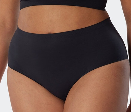 Eine Person trägt einen schwarzen, unsichtbaren SCHIESSER Invisible Slip Maxi.