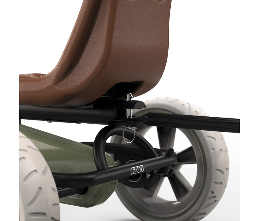 Nahaufnahme des hinteren Teils eines Go-Karts mit braunem Sitz, schwarzem Rahmen mit „FOXY“-Logo, grünem Gehäuse und weißen Rädern mit Profil. Ein Metallstift sichert den Sitz am Rahmen.