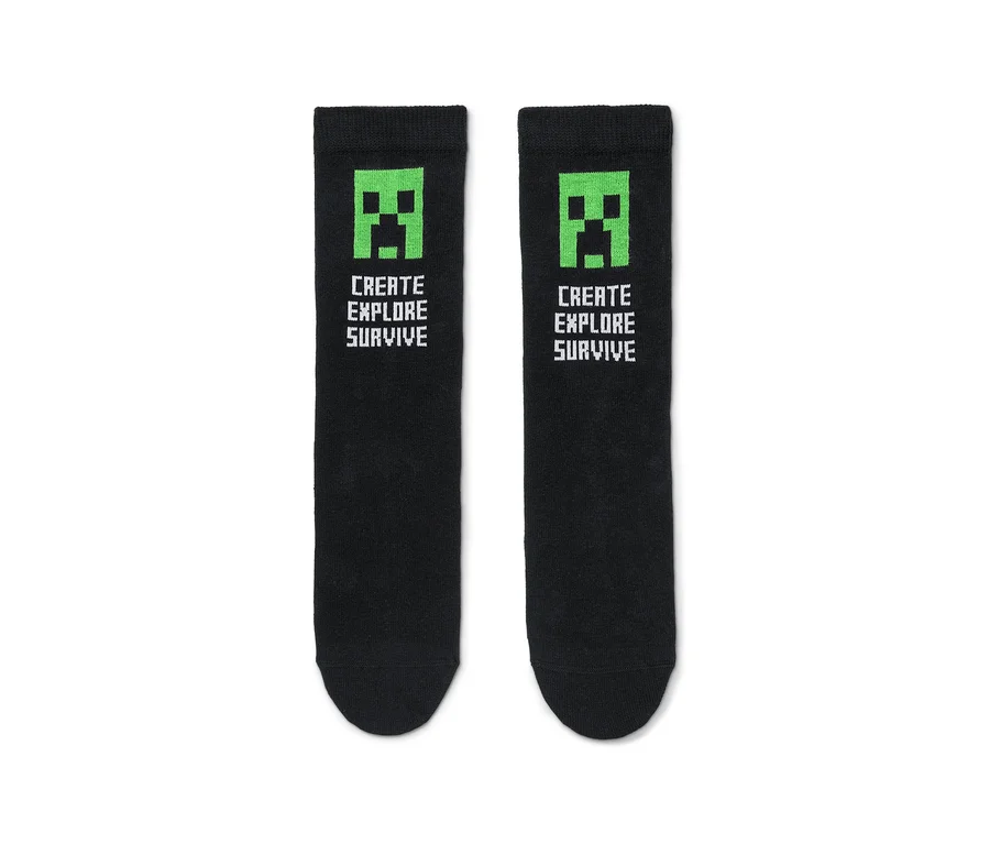 Zwei schwarze Socken mit grünem Minecraft-Creeper-Gesicht und dem Text "Create Explore Survive".