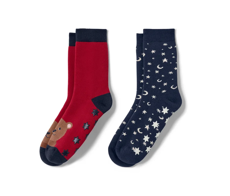 Zwei Paar Kinder-Antirutsch-Socken: ein Paar rot mit Bär, ein Paar dunkelblau mit Sternen und Monden.