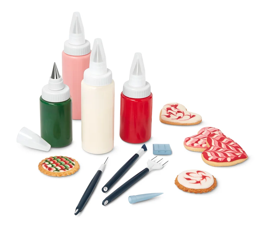 Royal-Icing-Set mit farbiger Glasur, Dekorationswerkzeugen und verzierten Keksen.