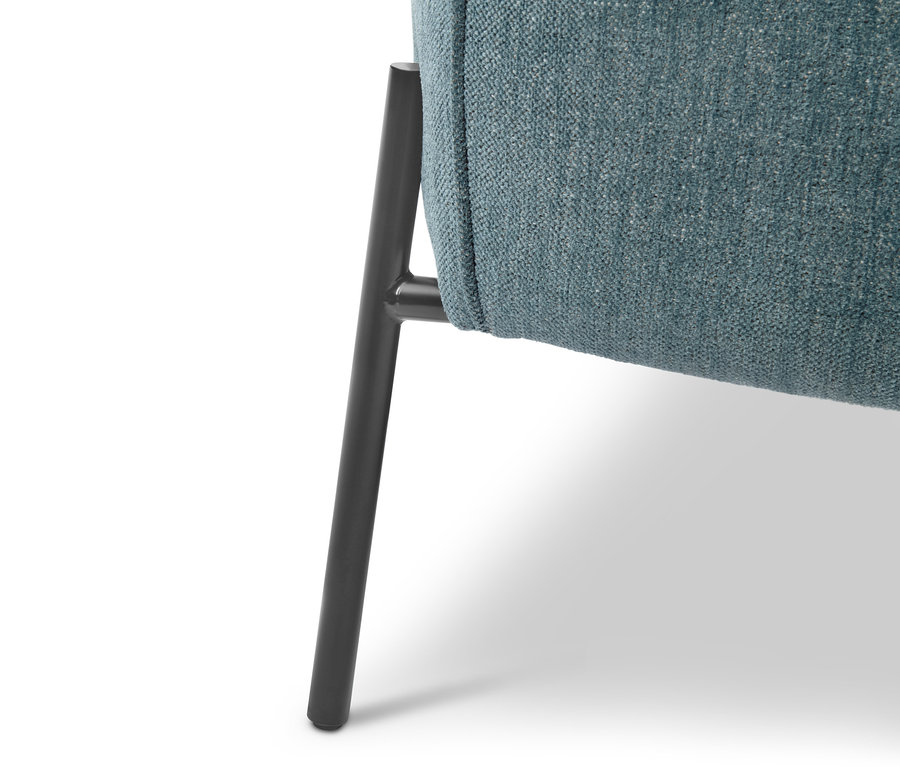 Detailansicht eines blauen Sessels mit Fußhocker und schwarzem Bein.