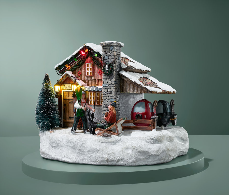Beleuchtetes Luville – Ski-Hotel Modell mit Skifahrerfiguren und verschneiter Landschaft.