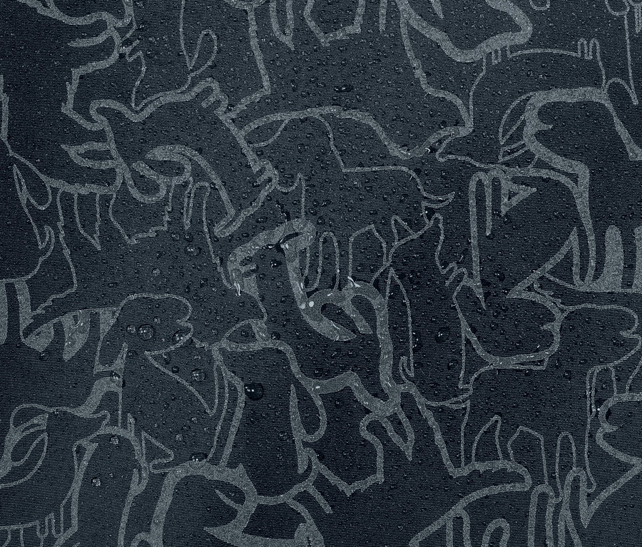 Detailansicht einer Kinder-Thermo-Regenjacke mit reflektierenden Elementen und Tiermuster, auf der sich Wassertropfen befinden.