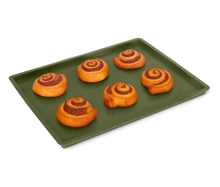 Sechs Zimtschnecken auf einer grünen Dauerbackmatte mit Rand.