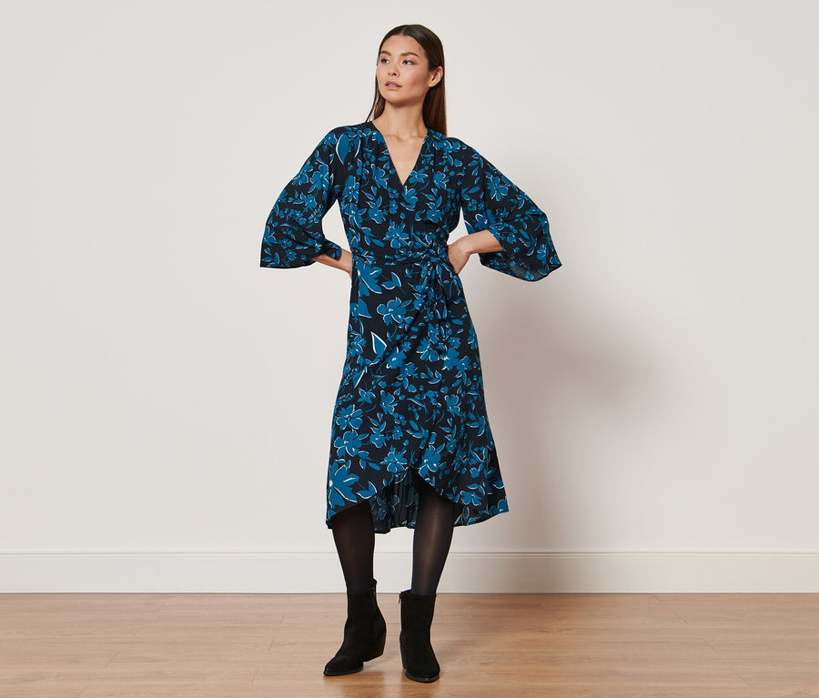 Frau posiert in einem Kleid mit Print.